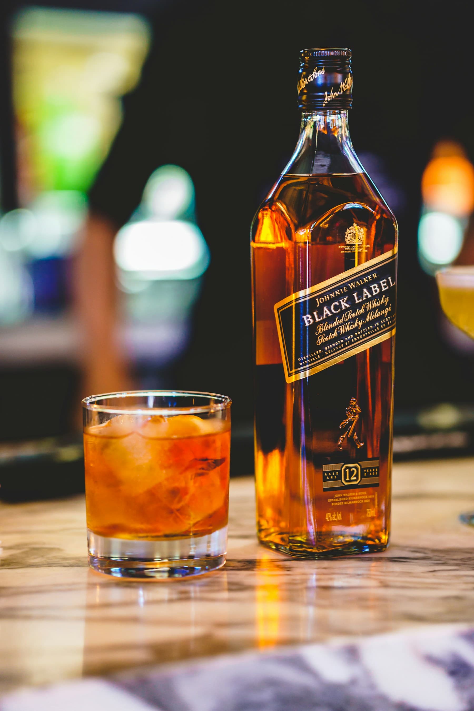 A Johnnie Walker Black Label bottle beside a whisky cocktail