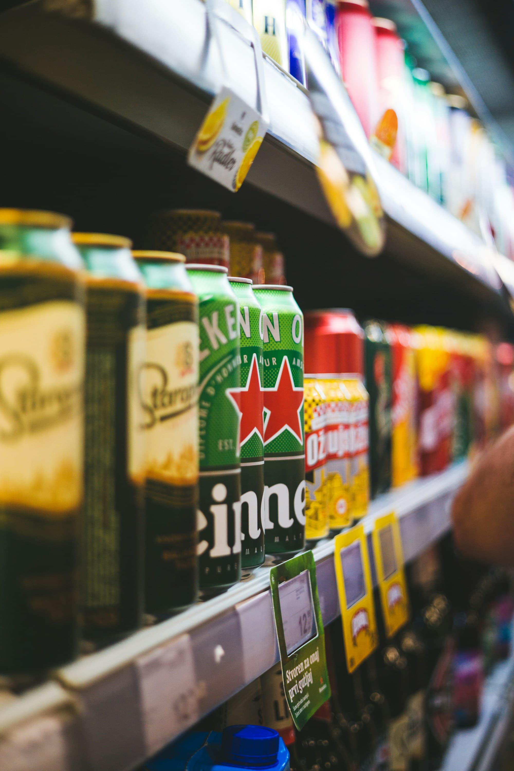 Heineken beer cans and other canned drinks on a shop shelf