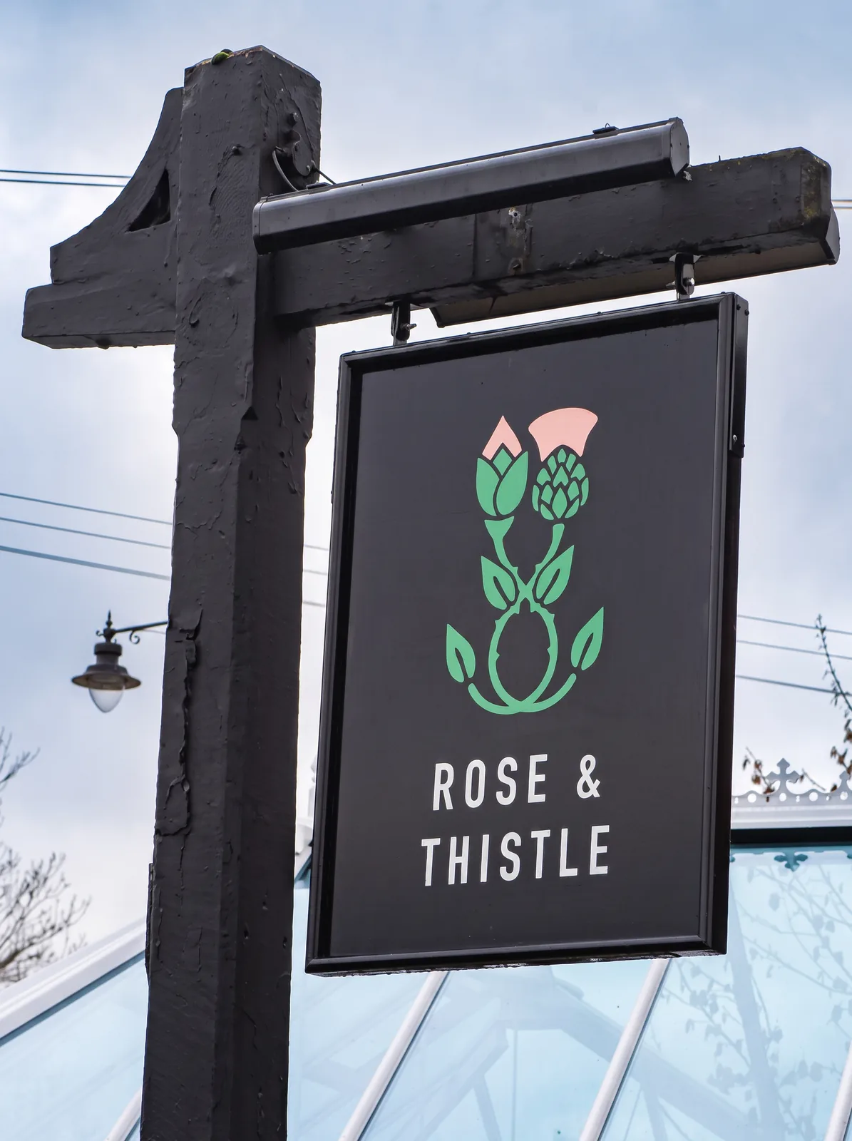 Rose and Thistle hanging pub sign with a simple flower illustration